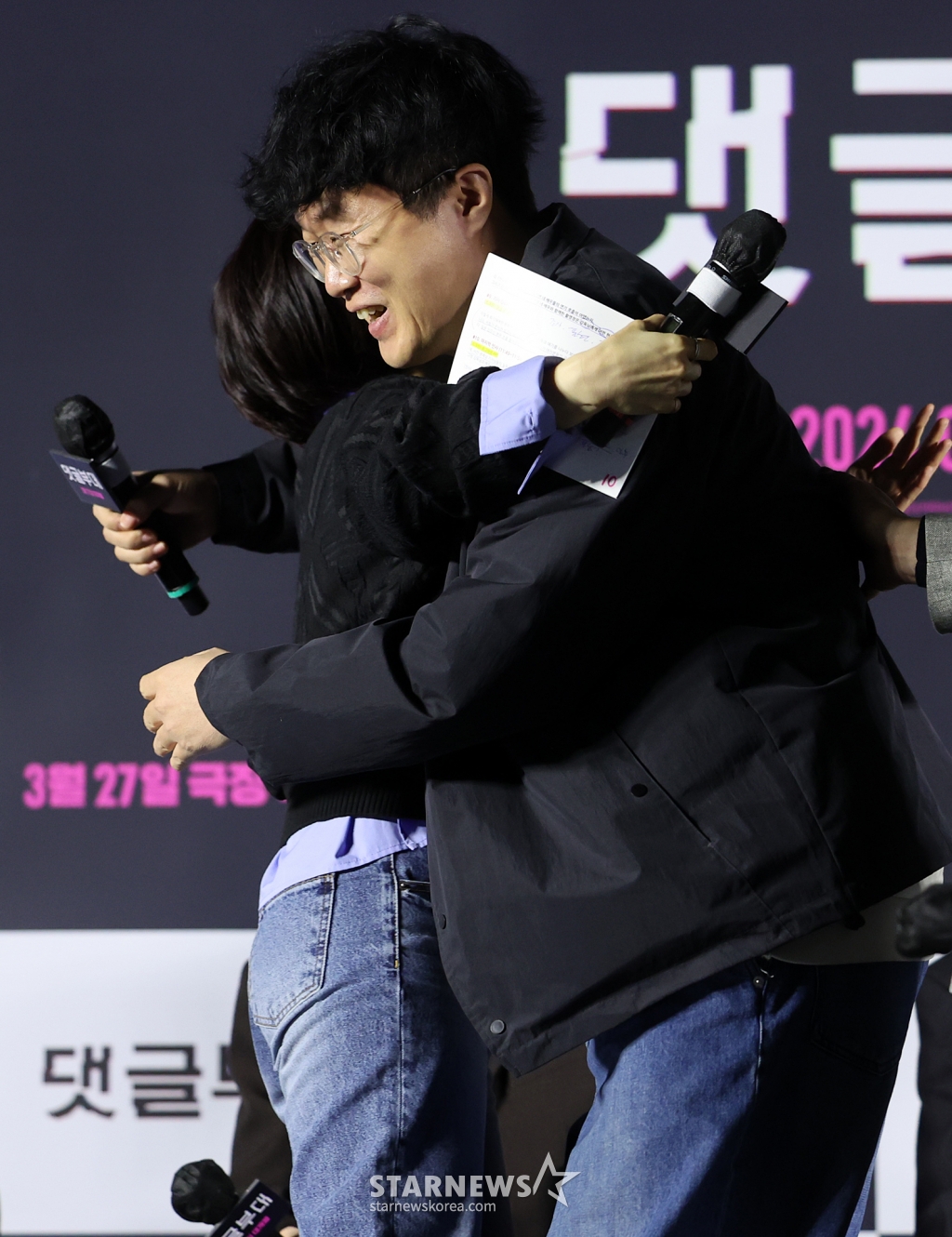 (서울=뉴스1) 김진환 기자 = 안국진 감독이 4일 서울 광진구 아차산로 롯데시네마 건대입구에서 열린 영화 ‘댓글부대’ 제작보고회에 참석해 군대 시절 라디오에 사연을 보냈던 일화를 밝힌 뒤 박경림과 포옹을 하고 있다. ‘댓글부대’는 대기업에 관한 기사를 쓴 후 정직당한 기자 임상진에게 온라인 여론을 조작했다는 익명의 제보자가 나타나면서 벌어지는 이야기를 다룬 영화로 오는 27일 개봉한다. 2024.3.4/뉴스1 Copyright (C) 뉴스1. All rights reserved. 무단 전재 및 재배포, AI학습 이용 /사진=(서울=뉴스1) 김진환 기자