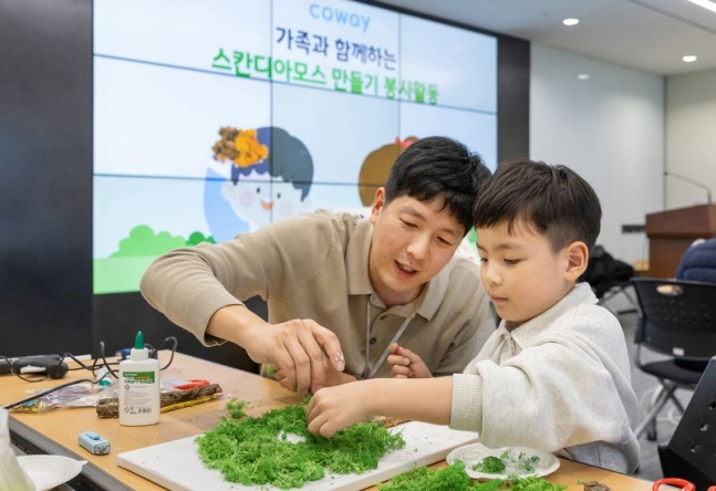 코웨이 직원이 가족과 함께 스칸디아모스 공기정화액자를 만들고 있다.