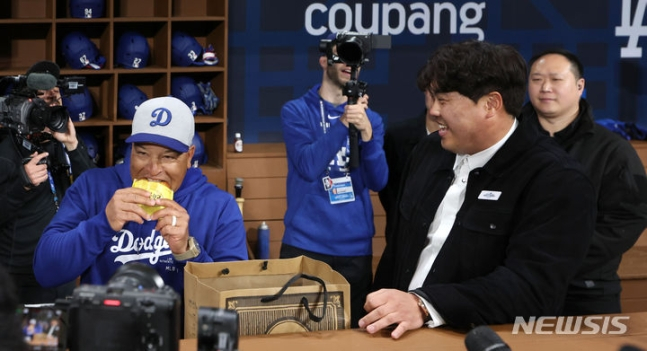 데이브 로버츠 LA 다저스 감독이 20일 서울 고척스카이돔에서 열린 미국프로야구(MLB) 공식 개막전 LA 다저스 vs 샌디에이고 파드리스 1차전 경기 시작 전 LA 더그아웃을 방문한 한화 류현진과 만나 선물받은 빵을 먹으며 대화하고 있다. /사진=뉴시스