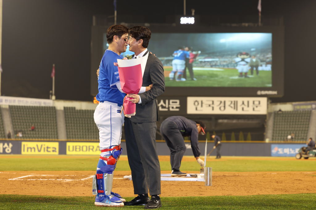 KBO 리그 최초 2238경기 출장 기록을 쓴 강민호를 향해 종전 기록 보유자인 박용택 야구 해설위원이 28일 잠실구장을 찾아 5회 클리닝 타임 때 축하 인사를 전하고 있다. /사진=LG 트윈스 제공