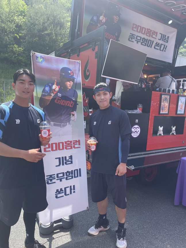 롯데 김대현(왼쪽)과 황성빈이 10일 주장 전준우가 보낸 커피차 앞에서 포즈를 취하고 있다. /사진=롯데 자이언츠 제공