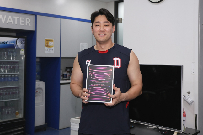 태블릿 PC를 지급받고 기념촬영을 하는 양석환. /사진=두산 베어스 제공