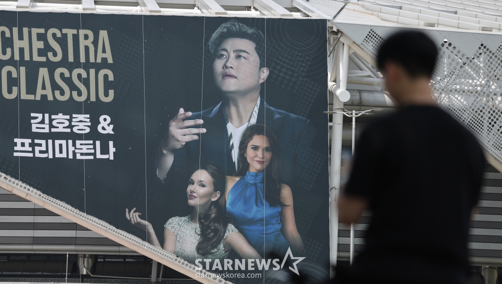 (서울=뉴스1) 박지혜 기자 = 22일 오후 서울 송파구 올림픽공원 KSPO돔(체조경기장)에 설치된 '월드 유니온 오케스트라 슈퍼 클래식 : 김호중 & 프리마돈나’ 현수막 앞으로 시민들이 지나가고 있다. ‘음주 뺑소니’ 혐의로 조사를 받고 있는 트로트 수 김호중(33)이 경찰의 구속영장 신청에도 오는 23~24일 예정된 클래식 공연에 나선다. 김호중의 소속사 생각 엔터테인먼트 측 관계자는 이날 뉴스1에 "경찰이 구속영장을 신청한 사실을 방금 확인했다"라며 "그럼에도 오는 23~24일로 예정된 공연은 진행할 계획"이라고 /사진=(서울=뉴스1) 박지혜 기자