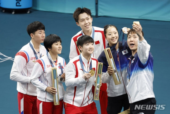 파리올림픽 탁구 혼합복식 메달리스트들이 30일(현지시간) 시상식에서 삼성 스마트폰으로 기념촬영을 하고 있다, 왼쪽부터 북한 리정식-김금용, 중국 왕추친(위)-쑨잉사, 한국 신유빈-임종훈. /사진=뉴시스