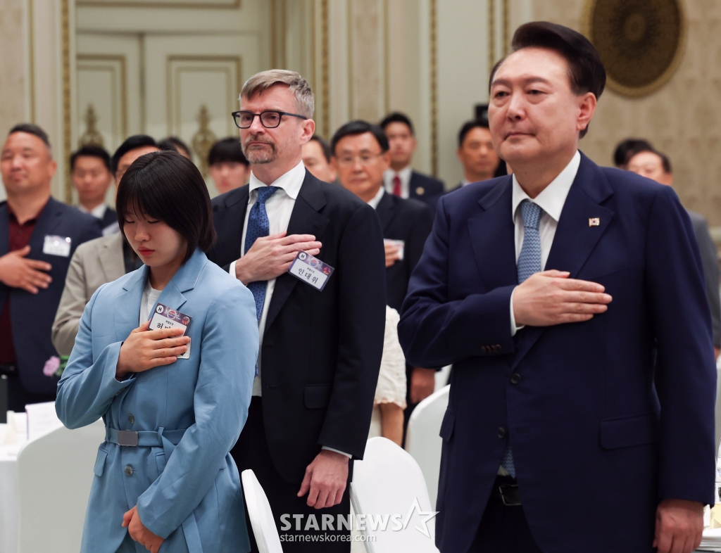 [서울=뉴시스] 최진석 기자 =  윤석열 대통령이 14일 청와대 영빈관에서 열린 독립유공자 후손 초청 오찬에서 독립유공자 후손 등을 비롯한 참석자들과 국기에 경례를 하고 있다. 왼쪽은 독립운동가 허석 의사의 후손인 2024 파리올림픽 유도 개인전 은메달, 혼성 단체전 동메달리스트 허미미. (대통령실통신사진기자단) 2024.08.14. myjs@newsis.com /사진=최진석