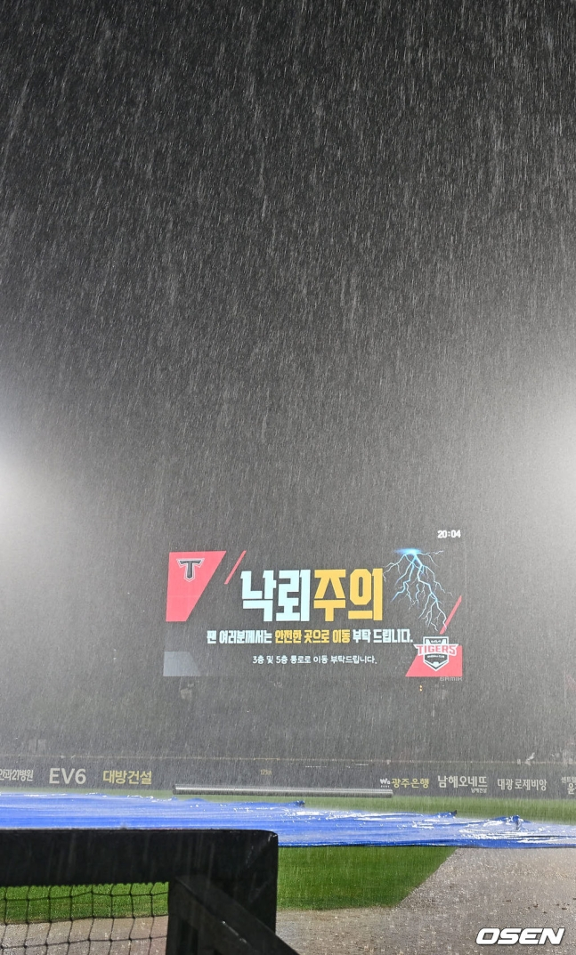 20일 광주-KIA 챔피언스필드에서 열린 롯데-KIA전이 4회 폭우로 인해 중단된 가운데, 번개가 수시로 치자 전광판을 통해 관중들에게 안전에 유의해줄 것을 당부하고 있다.