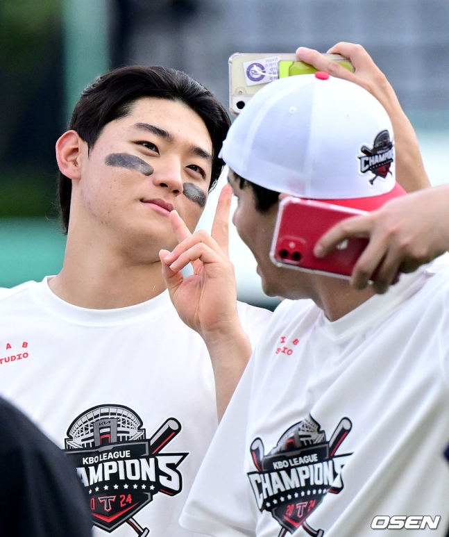 KIA 김도영(왼쪽)이 17일 인천 SSG전에서 정규 1위를 확정한 후 기념 사진을 찍고 있다.