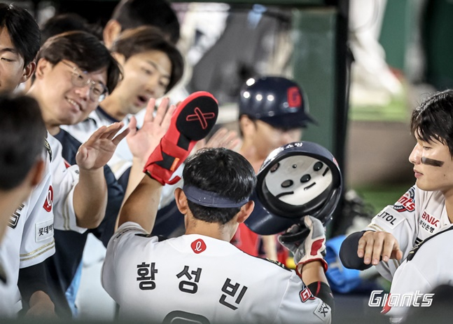 롯데 황성빈(가운데)이 27일 사직 NC전에서 득점한 후 동료들의 축하를 받고 있다. /사진=롯데 자이언츠 제공