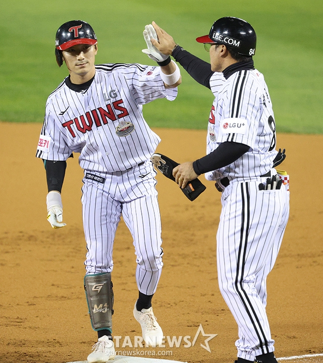 '2024 KBO 포스트시즌 준플레이오프 5차전' LG-,kt전이11일 서울 잠실야구장에서 열렸다. LG 신민재가 1회말 1사에서 좌전 안타를 날리고 출루한 후 박용근 코치의 환영을 받고 있다. /사진=김진경 대기자