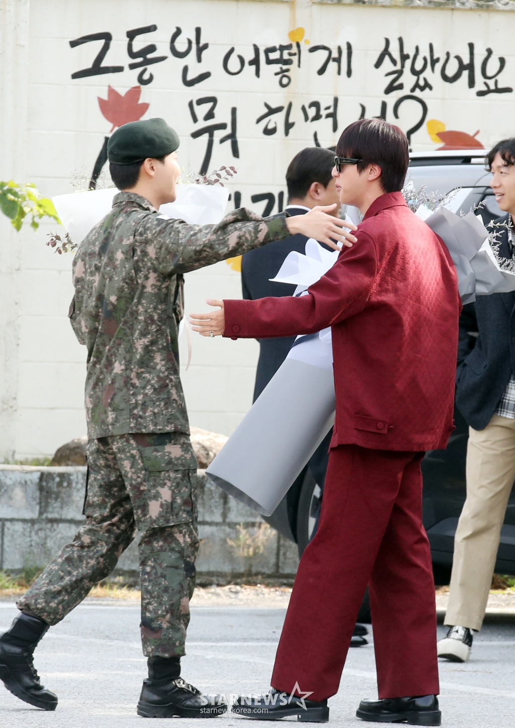 그룹 방탄소년단(BTS) 제이홉(29·정호석)이 17일 오전 강원도 원주시 제36보병사단 신병교육대대에서 만기 전역한 가운데 멤버 진이 꽃다발을 들고 포옹을 하고 있다. 2024.10.17 /사진=임성균