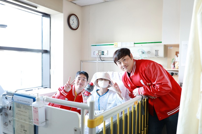 SSG 박종훈(왼쪾)과 이지영이 26일 오전 인하대병원을 방문해 어린이팬과 사진을 찍고 있다. /사진=SSG 랜더스 제공