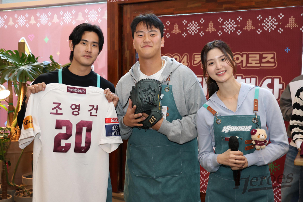키움 김건희(가운데)가 15일 서울 마곡동에 위치한 한 카페에서 열린 '2024 키움 히어로즈 연말자선행사'에서 조영건(왼쪽)의 글러브와 유니폼을 낙찰받고 미소 짓고 있다. /사진=키움 히어로즈 제공