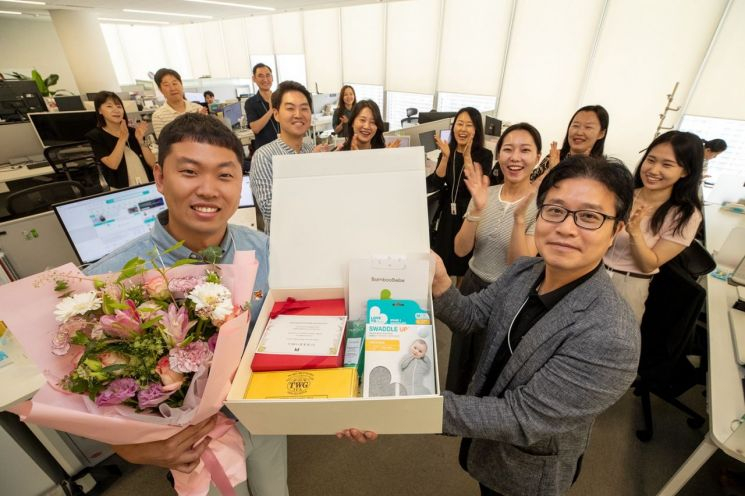 최근 서울 광화문 KT 사옥에서 한 직원이 회사로부터 '임신 축하 패키지' 선물을 받고 기념 사진을 촬영하고 있다