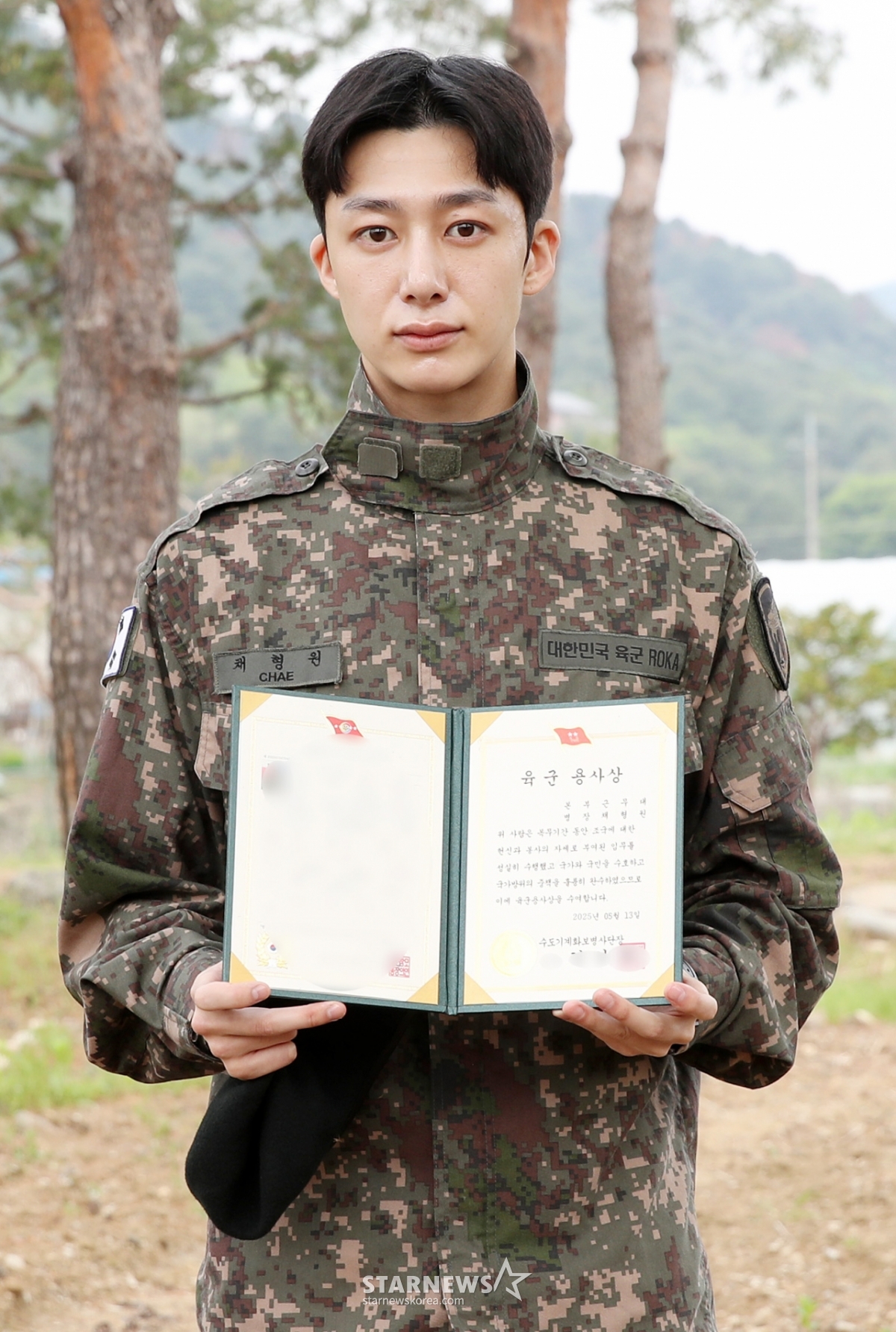 군 복무를 마친 그룹 몬스타엑스 형원이 13일 오전 경기도 가평군 조종면 수도기계화보병사단 앞에서 팬들에게 인사하고 있다. /2025.05.13 /사진=김휘선 hwijpg@