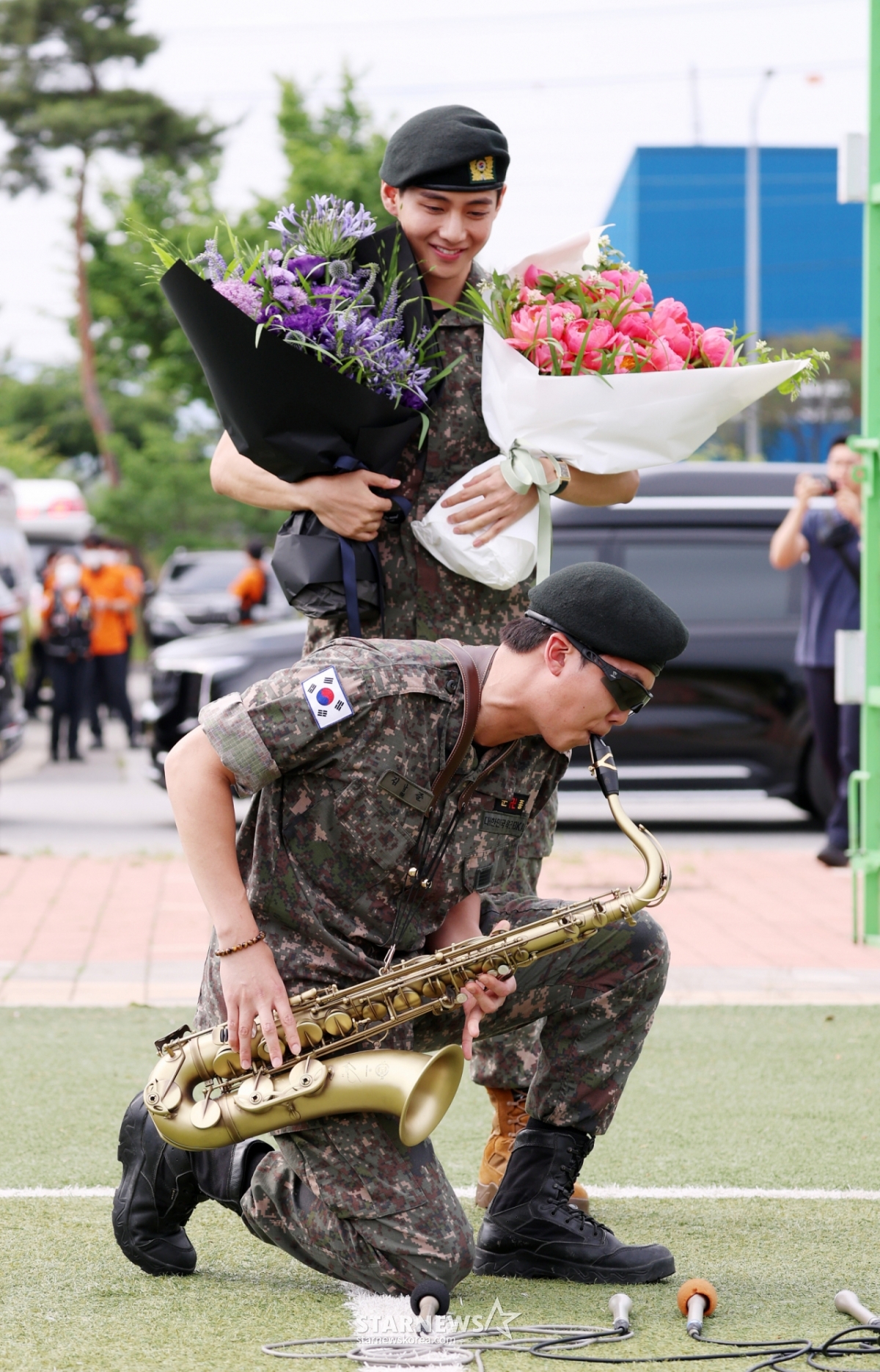 육군 제15보병사단 군악대로 복무한 RM, 육군 제2군단 군사경찰 특수임무대로 각 복무를 마친 뷔가 10일 오전 강원 춘천시 신북읍체육공원에서 팬들에게 인사를 하고 있다./2025.06.10 /사진=김휘선 hwijpg@