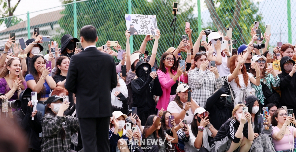 육군 제15보병사단 군악대로 복무한 RM, 육군 제2군단 군사경찰 특수임무대로 각 복무를 마친 뷔가 10일 오전 강원 춘천시 신북읍체육공원에서 전역 소감을 전하는 가운데 팬들이 환호하고 있다./2025.06.10 /사진=김휘선 hwijpg@