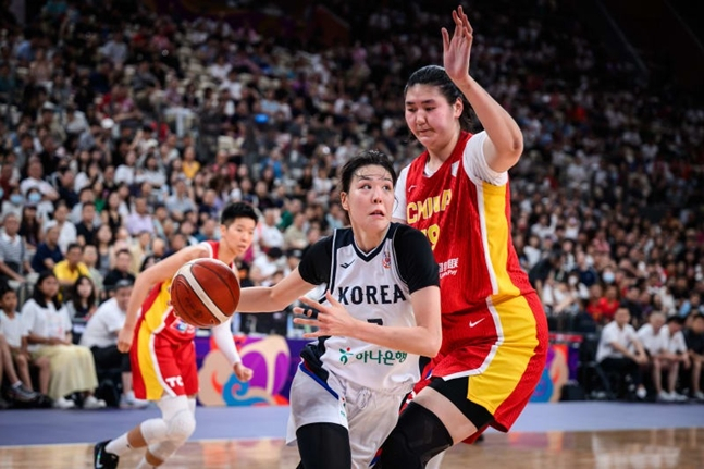 박지수(가운데)가 장쯔위를 상대로 돌파하고 있다. /사진=FIBA 공식 홈페이지
