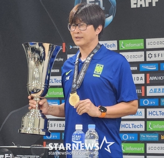 신상우 여자축구대표팀 감독이 취재진이 우승컵과 함께 포즈를 요구하자 수줍게 트로피를 들어보이고 있다. /사진=박건도 기자