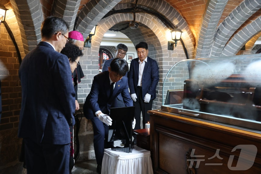 용호성(가운데) 문화체육관광부 제1차관이 29일 서울 중구 명동대성당 지하성당에 마련된 고 안충석 신부의 빈소를 찾아 국민훈장 모란장을 추서하고 있다. /사진=뉴스1(천주교서울대교구 제공)
