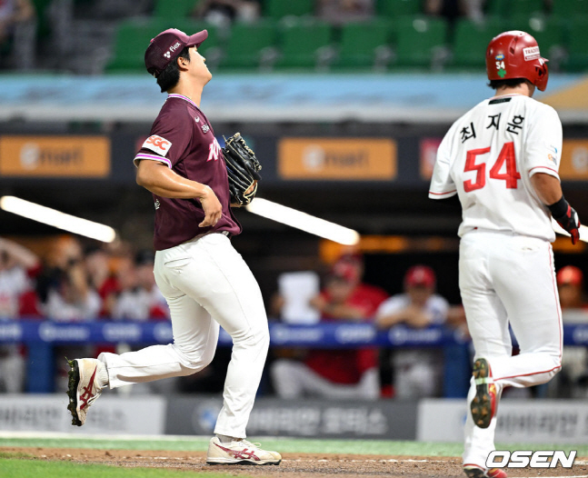 키움 투수 전준표가 31일 SSG전에서 8회말 1사 만루에서 폭투를 범하고 아쉬워하고 있다. SSG 최지훈은 결승 득점을 해내고 있다.