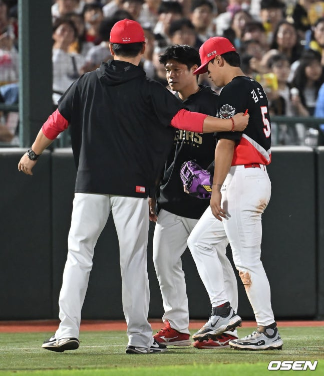 KIA 타이거즈 김도영(오른쪽)이 7일 부산 롯데전에서 5회말 무사 1루 상황 때 롯데 자이언츠 윤동희의 타구를 처리하다가 왼쪽 햄스트링 쪽에 통증을 느낀 뒤 교체 아웃되고 있다. 