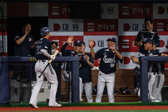 강승호(왼쪽)가 8회 홈런을 터뜨린 뒤 코칭스태프의 환영 속에 더그아웃으로 돌아가고 있다. /사진=두산 베어스 제공