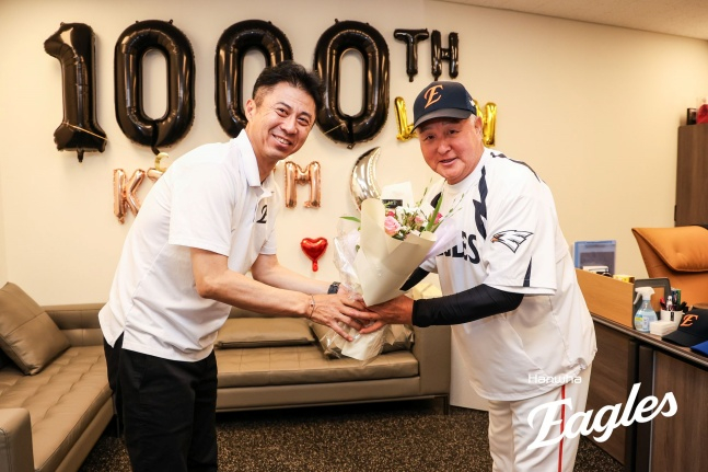 한화 손혁 단장이 12일 대전 롯데전 후 프로 통산 1000승을 기록한 김경문 감독에게 축하의 꽃다발을 전하고 있다. /사진=한화 이글스 제공