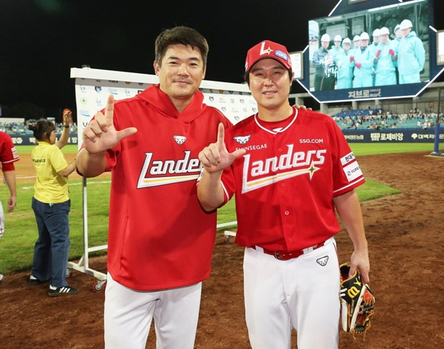 SSG 노경은(왼쪽)과 최정이 11일 삼성전에서 KBO 최초 3년 연속 30홀드, 10년 연속 20홈런 대업을 달성한 뒤 함께 기념촬영을 하고 있다. /사진=SSG 랜더스 제공