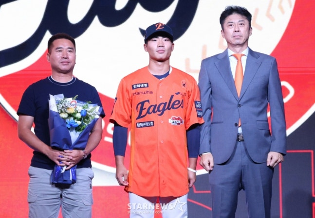 '2026 KBO 신인 드래프트'가 17일 서울 송파구 롯데호텔 월드 크리스탈볼룸에서 열렸다.  오재원(유신고)이 전체 3순위로 한화에 지명된 후 아버지, 손혁 단장과 기념촬영을 고 있다.  /사진=김진경 대기자 