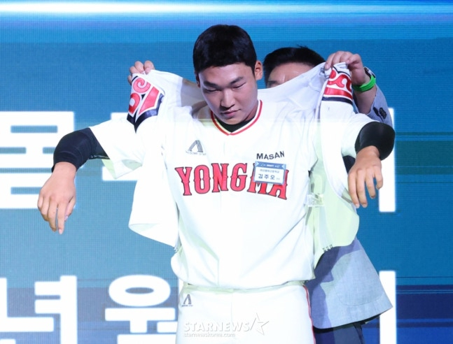 '2026 KBO 신인 드래프트'가 17일 서울 송파구 롯데호텔 월드 크리스탈볼룸에서 열렸다.  김주오(마산용마고)가 전체 7순위로 두산에 지명된 후 김태룡 단장의 도움을 받아 유니폼을 입고 있다. /사진=김진경 대기자